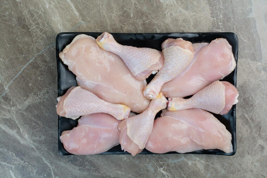 fresh-unprepared-chicken-legs-dark-plate-high-quality-photo_114579-64780